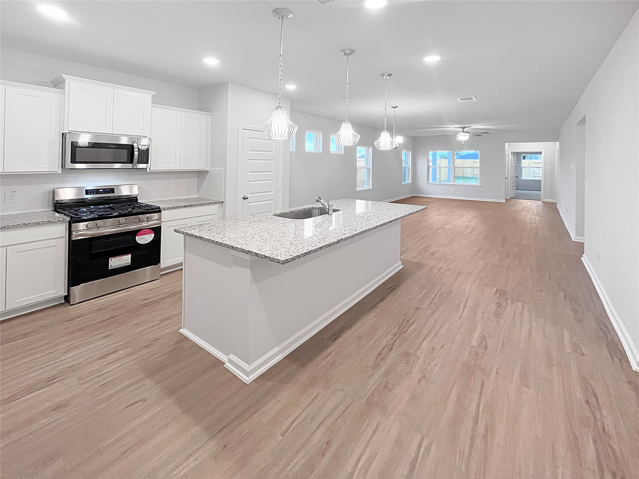 9706 Enclave Ridge Road Willis, TX 77318 - Photo 5 of 19 a large kitchen with stainless steel appliances granite countertop a lot of counter space and wooden floor