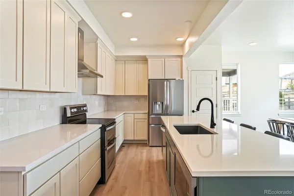 a kitchen with white cabinets appliances and sink