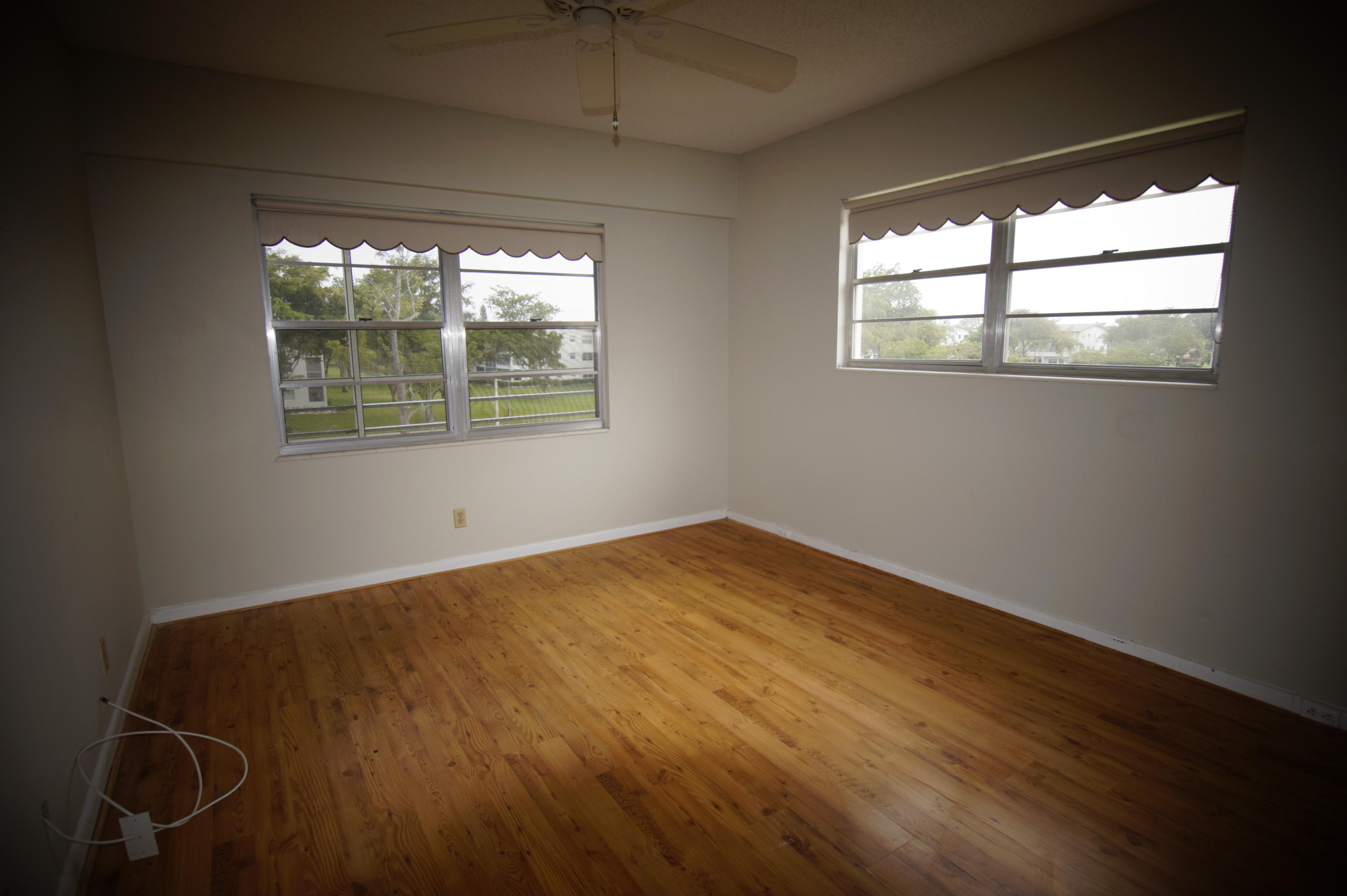 333 Preston H, Unit H Boca Raton, FL 33434 - Photo 4 of 10 an empty room with wooden floor and windows