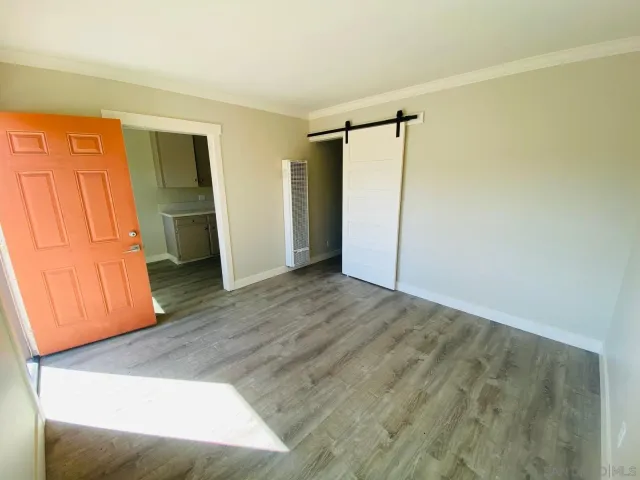 a view of empty room with wooden floor and cabinet
