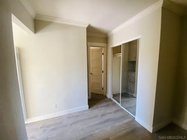 a view of a hallway with wooden floor and closet