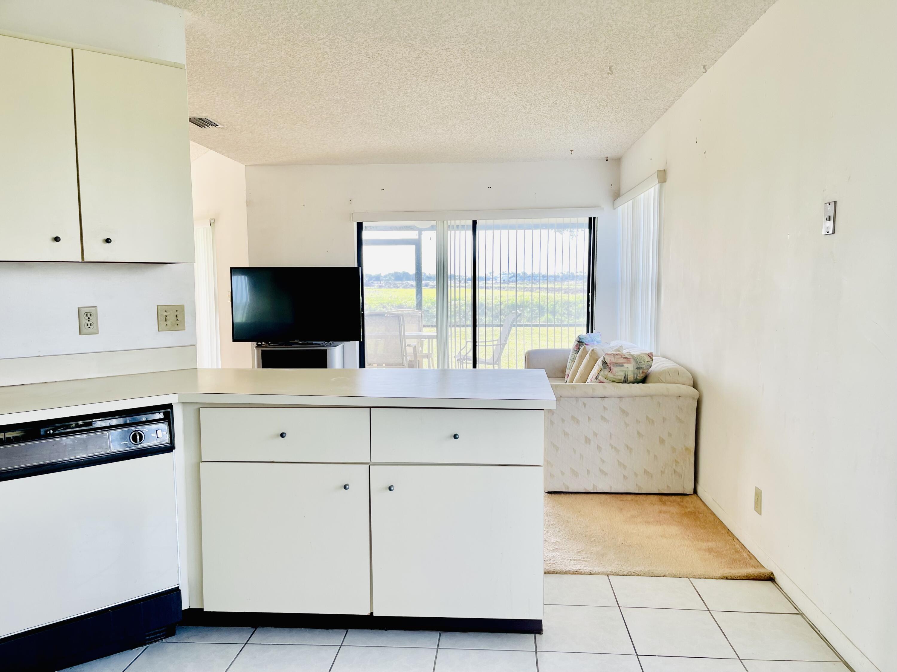 9690 Triton Court Boca Raton, FL 33434 - Photo 5 of 33 a living room with granite countertop furniture and a flat screen tv
