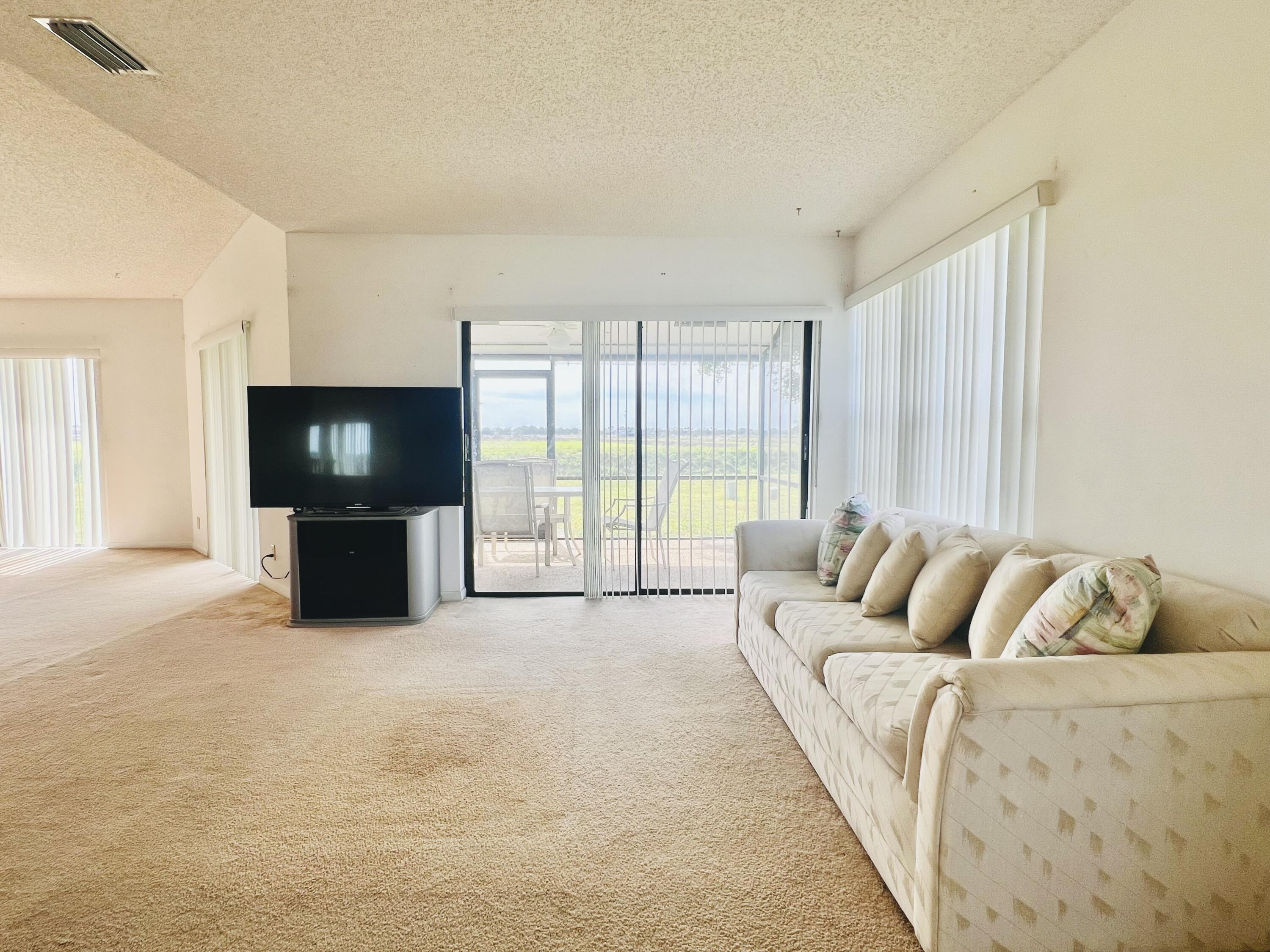 9690 Triton Court Boca Raton, FL 33434 - Photo 6 of 33 a living room with furniture and a flat screen tv