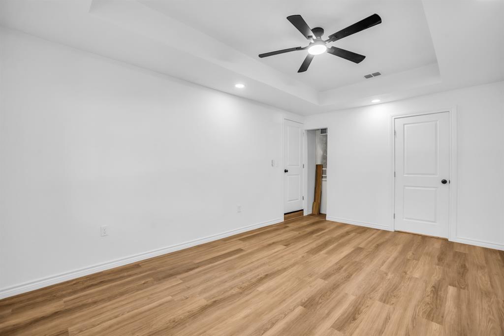 2108 Blake Avenue Dallas, TX 75228 - Photo 16 of 24 Unfurnished bedroom with a tray ceiling, light wood-style flooring, a ceiling fan, and recessed lighting