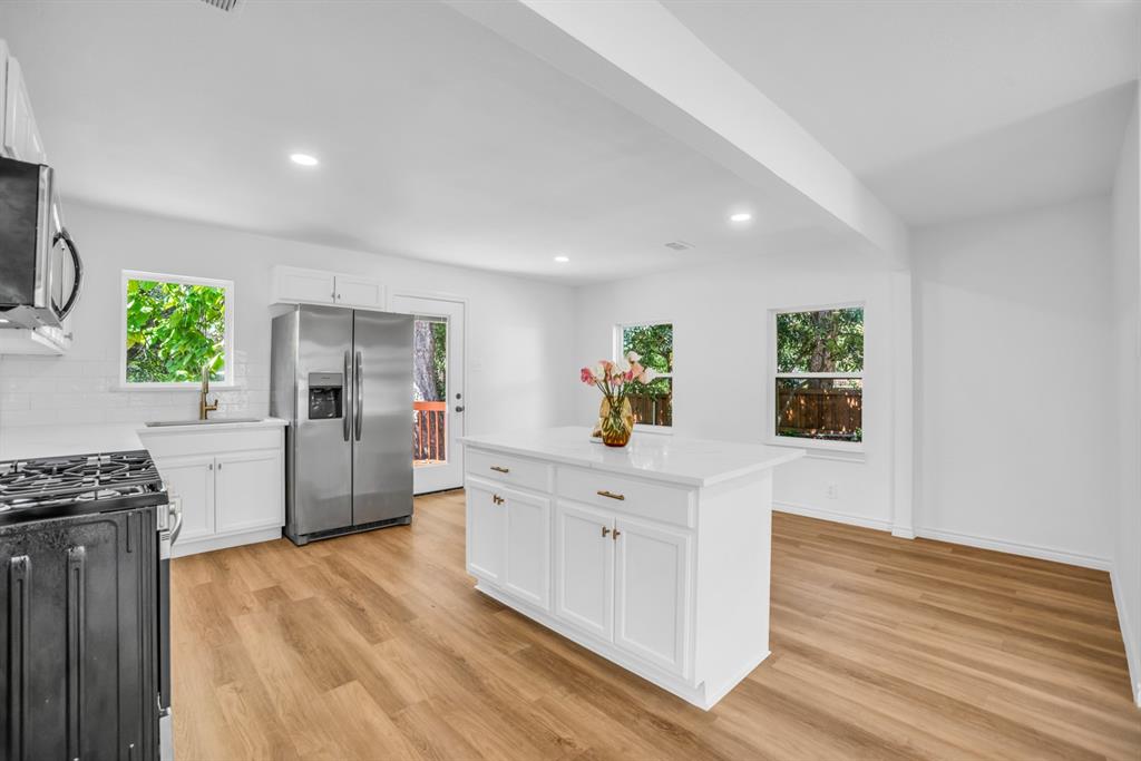 2108 Blake Avenue Dallas, TX 75228 - Photo 7 of 24 Kitchen featuring appliances with stainless steel finishes, a center island, white cabinetry, plenty of natural light, and recessed lighting
