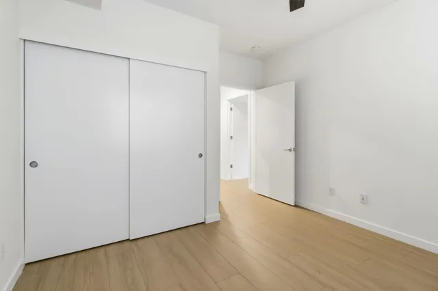 an empty room with a window and a ceiling fan