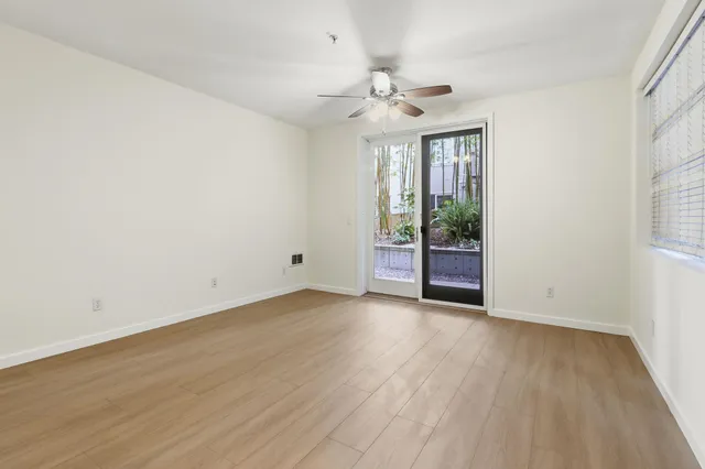 an empty room with wooden floor and windows