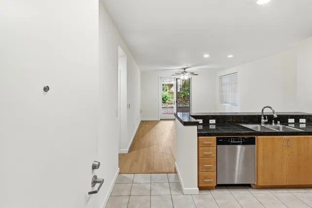 a kitchen with granite countertop a refrigerator and a sink