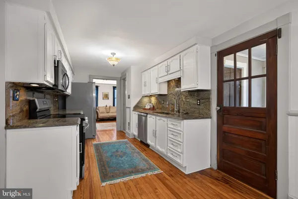 a kitchen with stainless steel appliances granite countertop a stove a sink dishwasher and cabinets with wooden floor