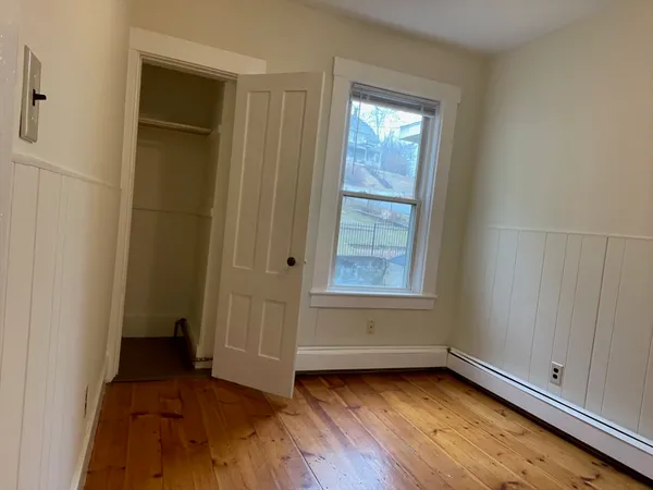 a view of a room with wooden floor and window
