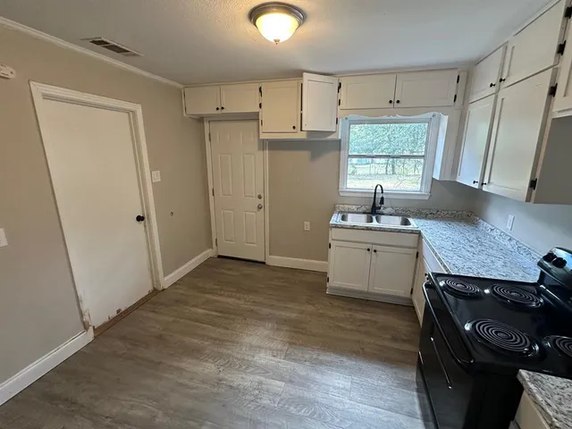 a kitchen with granite countertop a sink stove and refrigerator