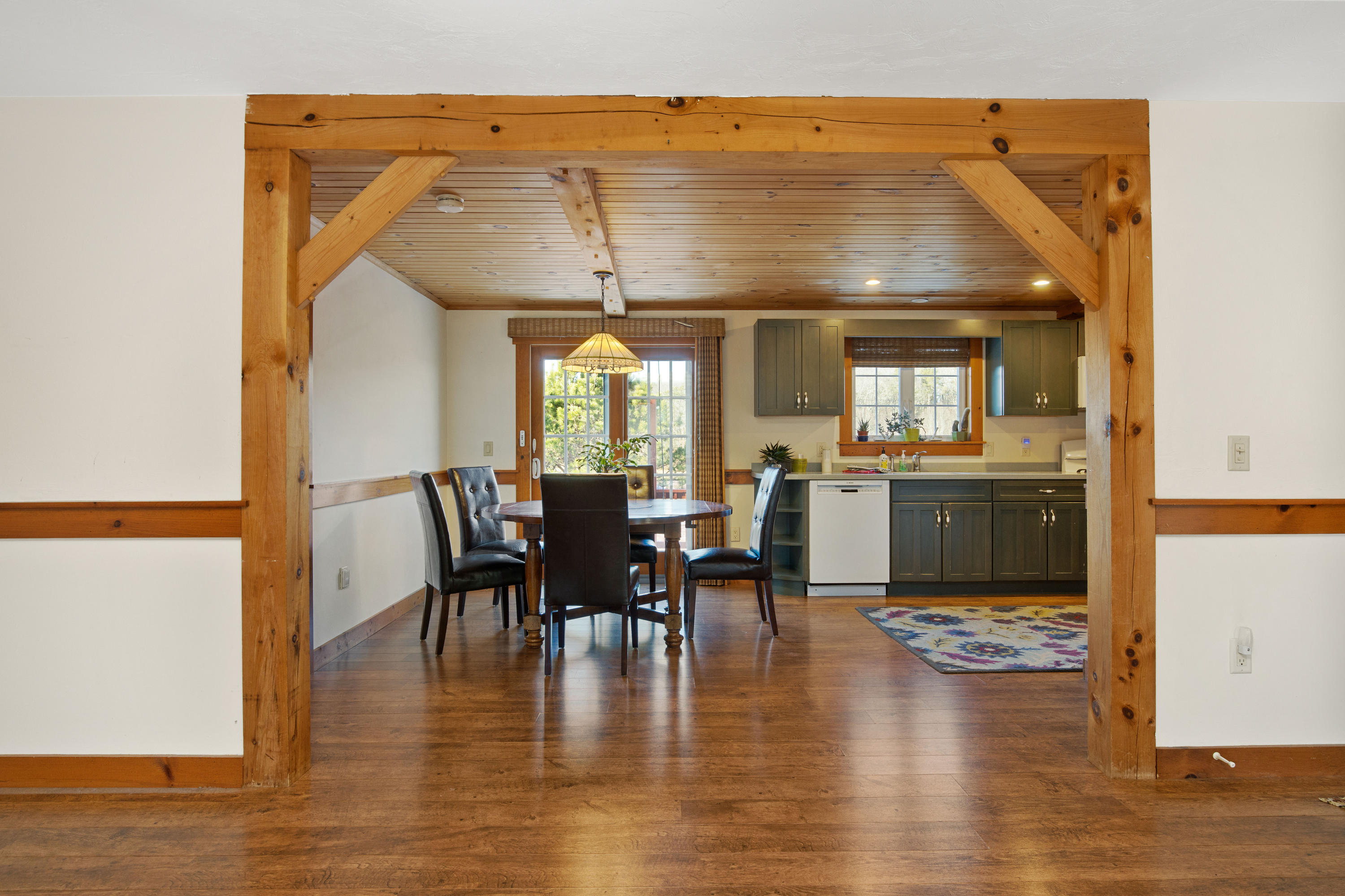 141 Bog Road Marstons Mills, MA 02648 - Photo 24 of 59 a view of dining room and livingroom with furniture wooden floor a rug and a kitchen view
