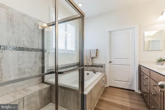 a bathroom with a tub sink and mirror