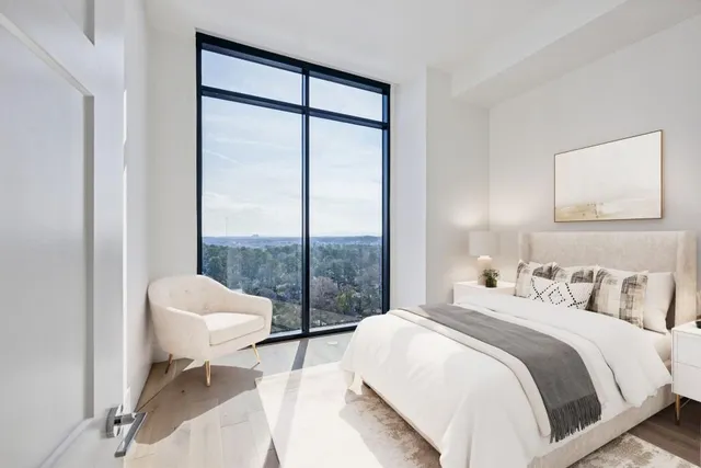 a bedroom with a bed and a large window