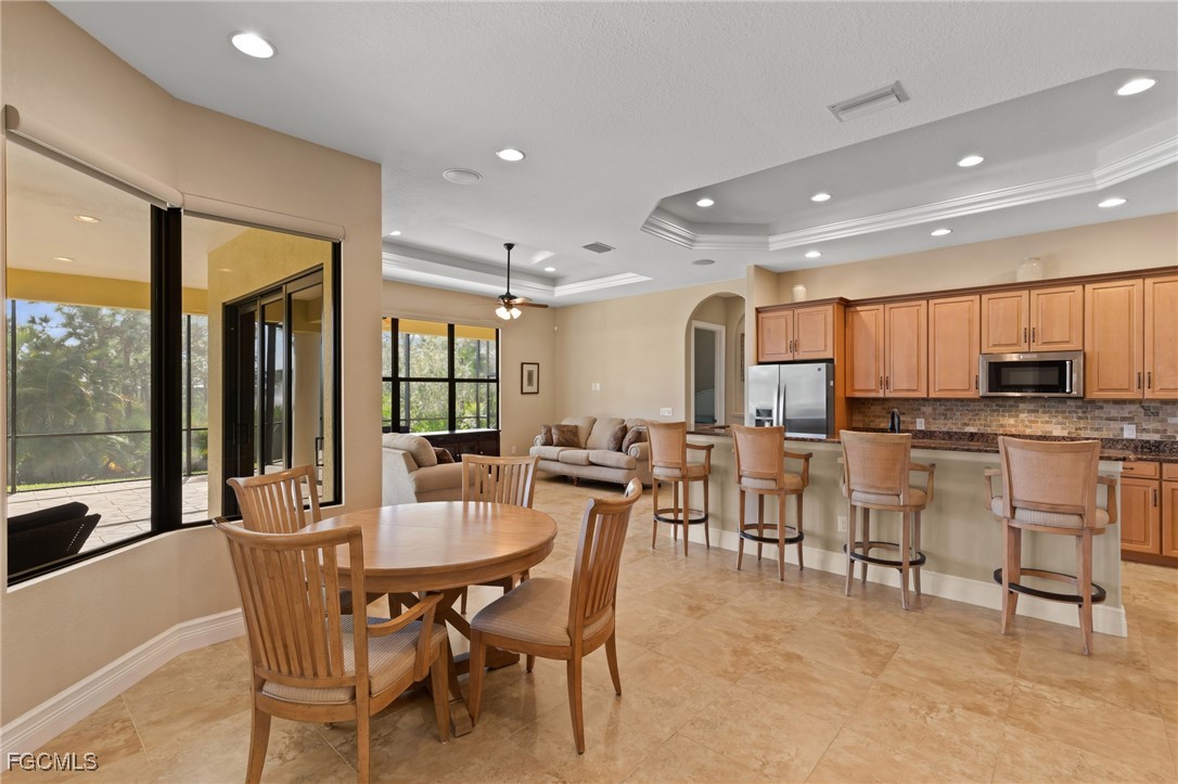6057 Calusa Rdg Trail Bokeelia, FL 33922 - Photo 11 of 45 a dining area with stainless steel appliances kitchen island granite countertop a dining table chairs and view living room