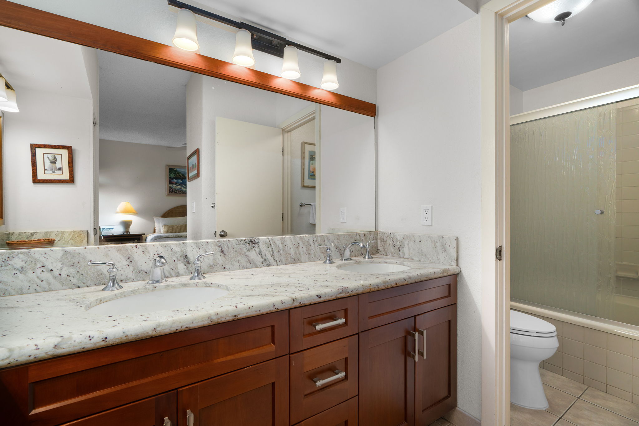 1565 Pe'e Road, Unit 418 Koloa, HI 96756 - Photo 14 of 30 a bathroom with a granite countertop sink a toilet and a shower