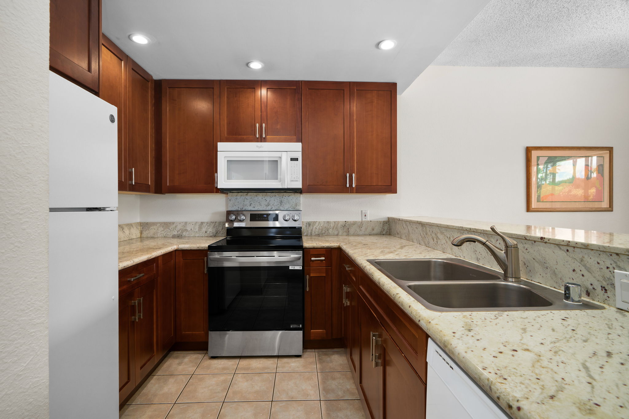 1565 Pe'e Road, Unit 418 Koloa, HI 96756 - Photo 4 of 30 a kitchen with a sink stove and cabinets