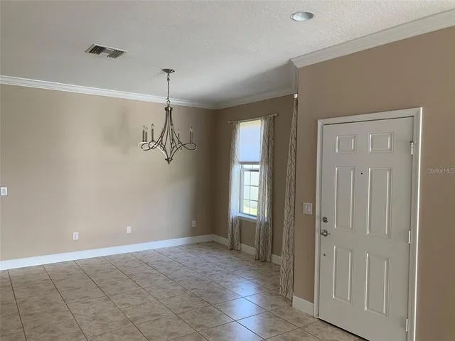 a view of a room with an empty space and windows