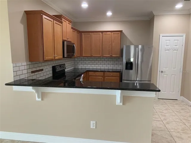 a kitchen with stainless steel appliances granite countertop a sink a stove and a refrigerator