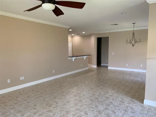 an empty room with fan and windows