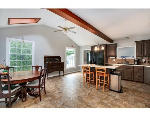 65 Barnett Road Sutton, MA 01590 - Photo 14 of 23 a open dining room with stainless steel appliances kitchen island granite countertop a table chairs and a refrigerator