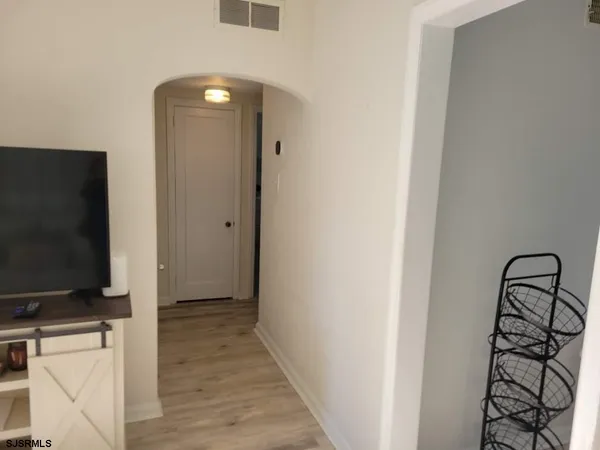 a view of a livingroom with wooden floor and furniture