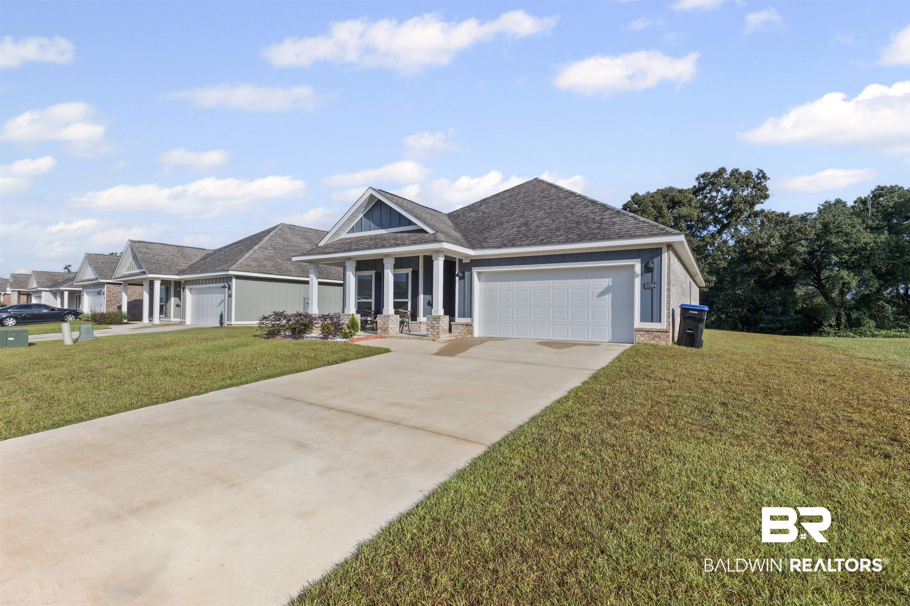 10564 Heirloom Road South Mobile, AL 36608 - Photo 4 of 24 View of front of home featuring covered porch, a front lawn, concrete driveway, and an attached garage