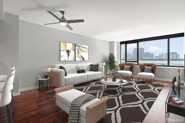 a living room with furniture a large window and wooden floor