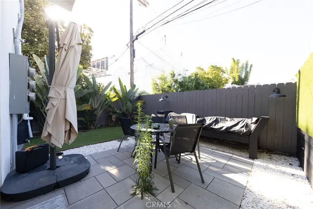 a view of a chairs and table in the back yard of the house