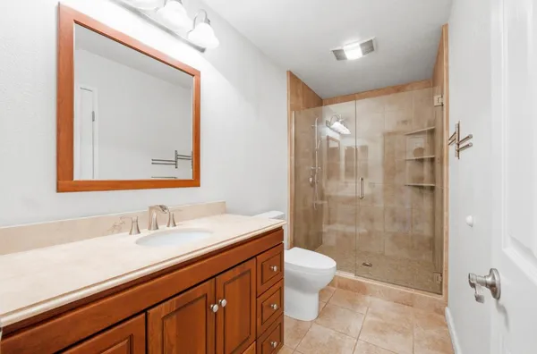 a bathroom with a sink a toilet and shower