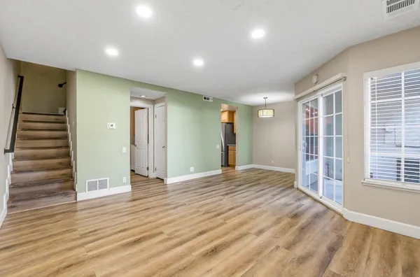 a view of empty room with wooden floor and entryway