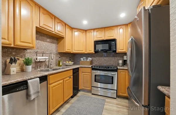 a kitchen with stainless steel appliances granite countertop a stove a sink and a refrigerator