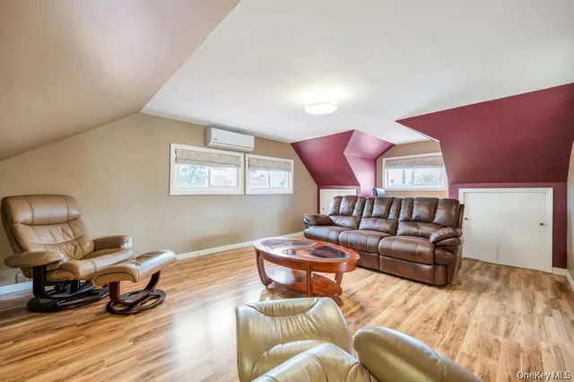 a living room with furniture a wooden floor and a large window