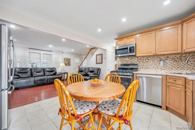 a dining room with stainless steel appliances a table and chairs