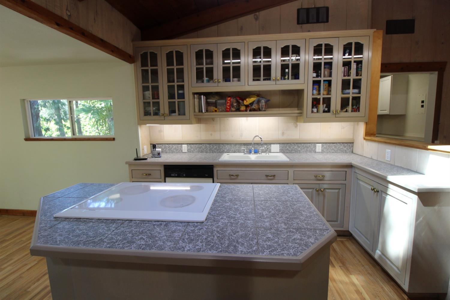 8775 North Applegate Road Grants Pass, OR 97527 - Photo 15 of 31 a kitchen with kitchen island a counter top space a stove and cabinets