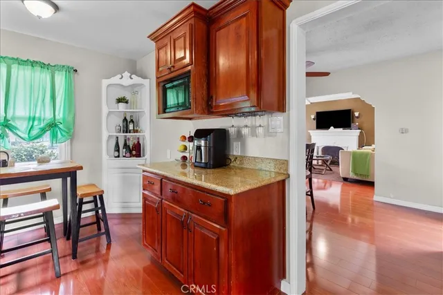a kitchen with stainless steel appliances granite countertop a stove a sink dishwasher and cabinets with wooden floor
