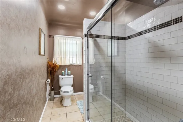 a bathroom with a granite countertop toilet a sink and a mirror