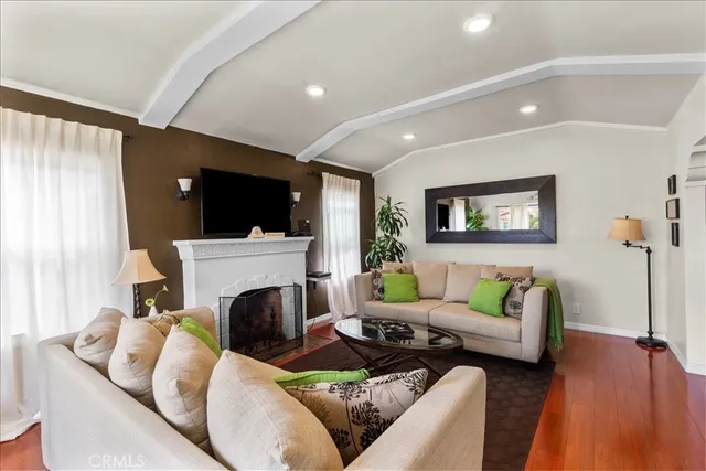 a living room with furniture a flat screen tv and a window