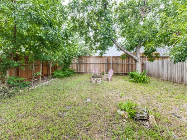 a view of a backyard with a small cabin and wooden fence