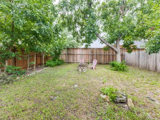 a view of a backyard with a small cabin and wooden fence