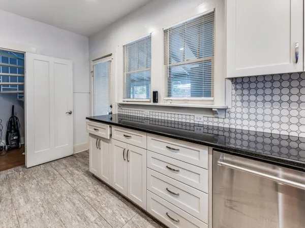a kitchen with granite countertop white cabinets and a sink