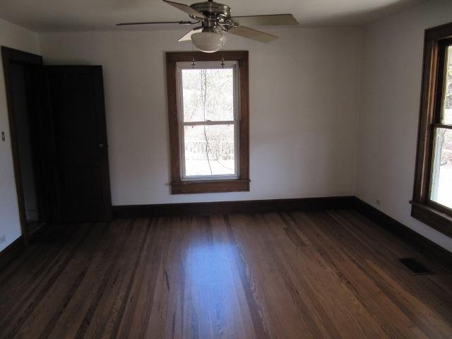 2059 Burkette Road Elliston, VA 24087 - Photo 4 of 18 an empty room with wooden floor a ceiling fan and windows