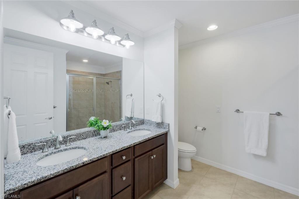 14795 Edgewater Circle Naples, FL 34114 - Photo 15 of 39 a bathroom with a granite countertop double vanity sink and a mirror