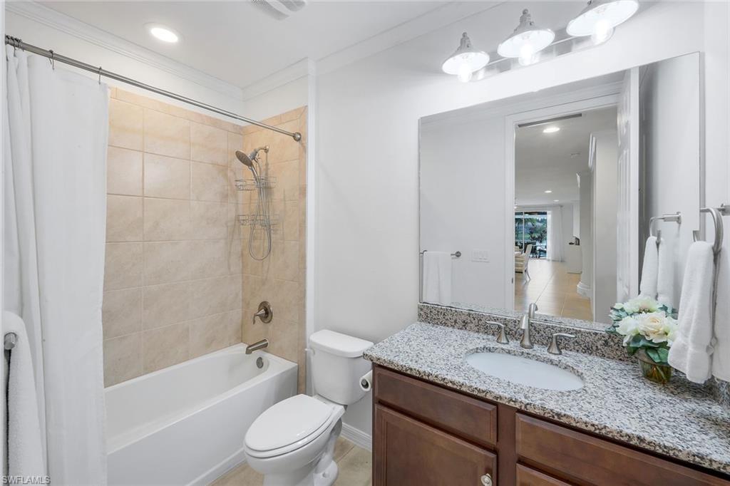 14795 Edgewater Circle Naples, FL 34114 - Photo 19 of 39 a bathroom with a granite countertop sink a toilet and bathtub