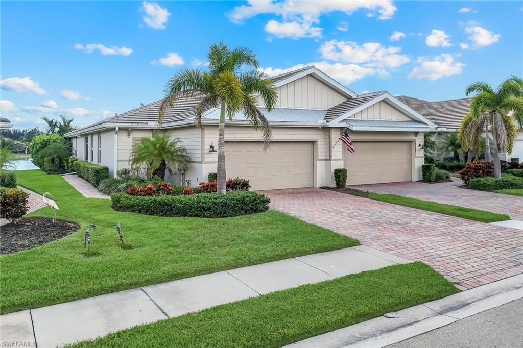 14795 Edgewater Circle Naples, FL 34114 - Photo 28 of 39 a front view of a house with a garden and plants