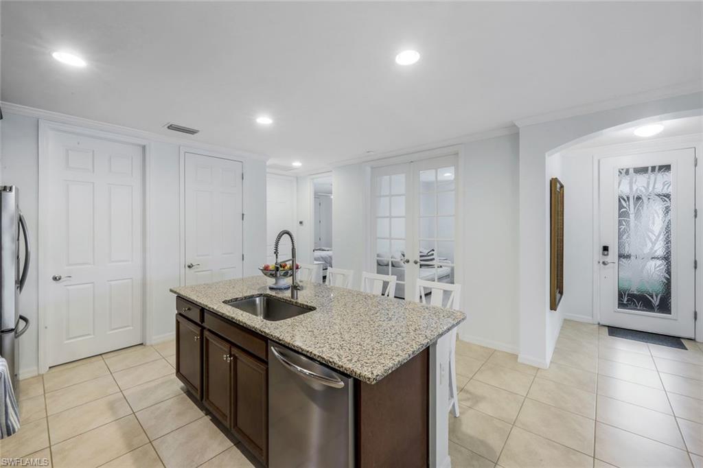 14795 Edgewater Circle Naples, FL 34114 - Photo 10 of 39 a kitchen with stainless steel appliances granite countertop a sink and a refrigerator