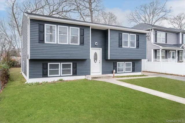 a front view of a house with a garden and yard