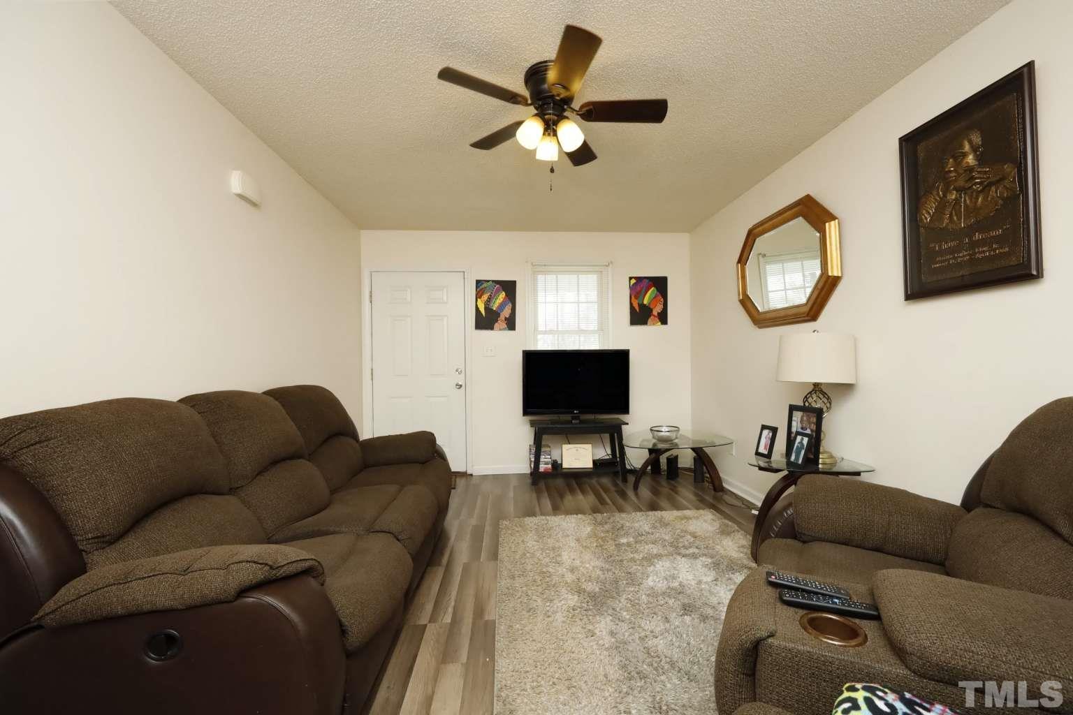 802 South Webb Street Selma, NC 27576 - Photo 3 of 25 a living room with furniture a clock and a ceiling fan