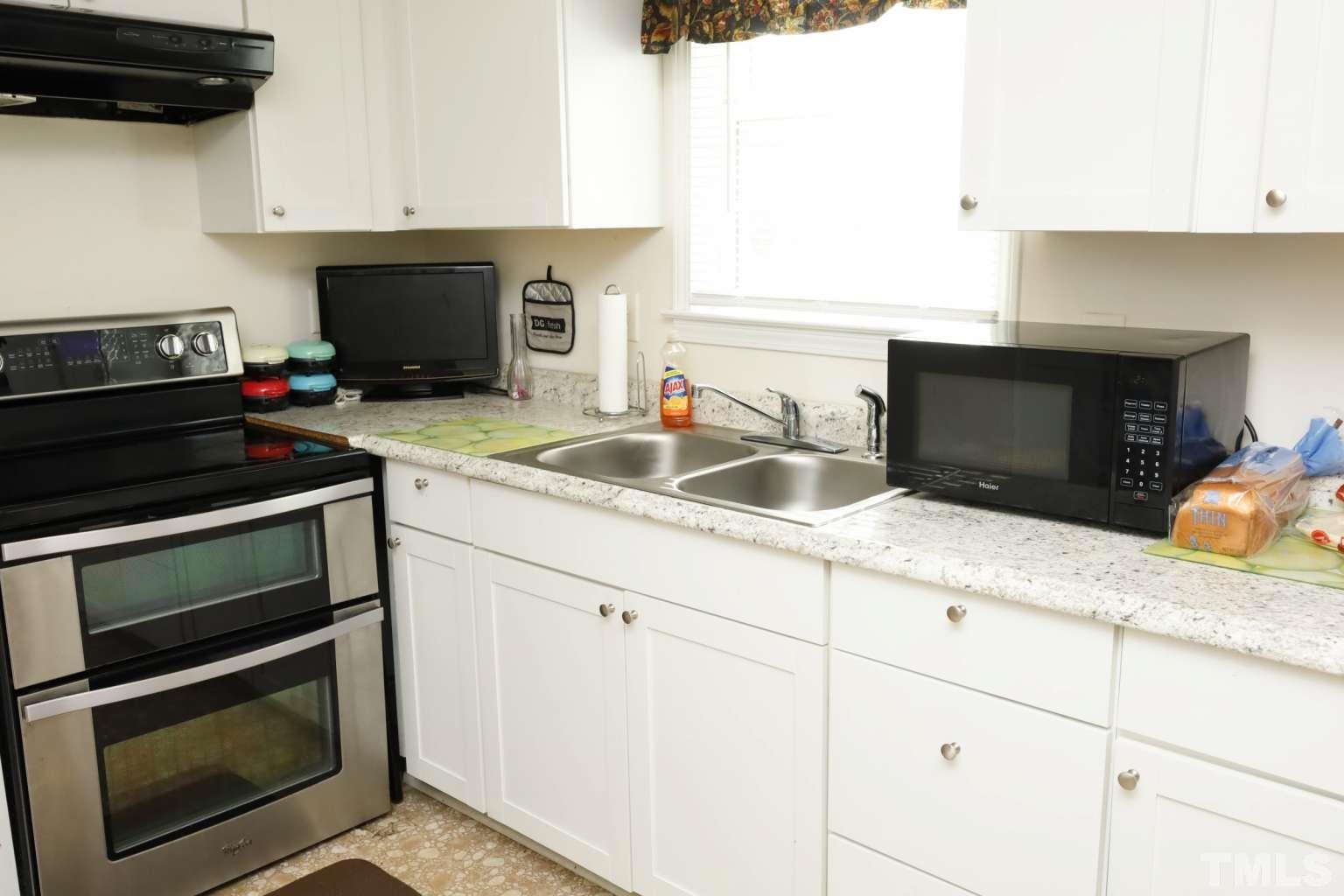 802 South Webb Street Selma, NC 27576 - Photo 7 of 25 a kitchen with granite countertop a stove microwave and sink