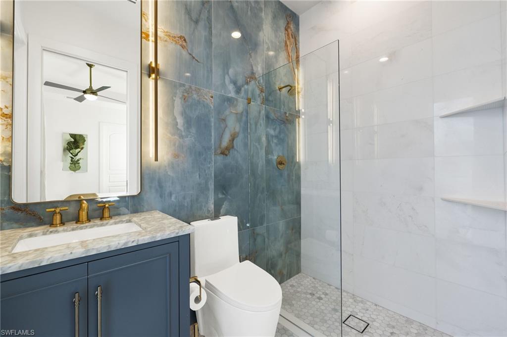 1955 Tarpon Road Naples, FL 34102 - Photo 20 of 48 Bathroom featuring vanity, a walk in shower, and a ceiling fan